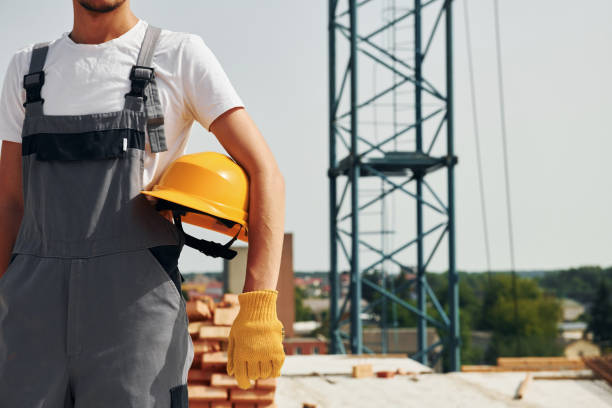 istock Close up view. Young construction worker in uniform is busy at the unfinished building 1368559267