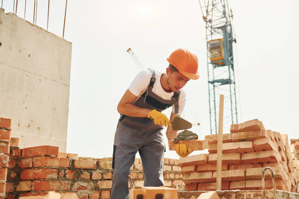 istock Young construction worker in uniform is busy at the unfinished building 1368559417