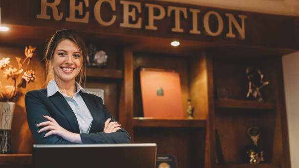 istock Confident receptionist with arms crossed at the hotel reception 1368559474