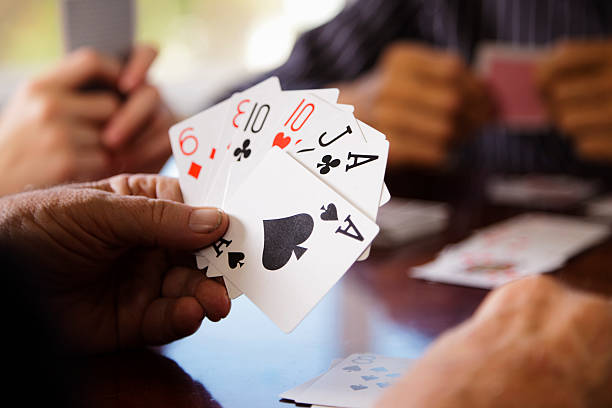 Close up of Gin Player's Hands A close-up of a player's hand in a card game of gin. rummy game stock pictures, royalty-free photos & images