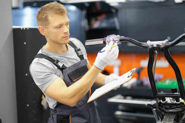 istock Garage service worker check wheel on motorbike, hold clipboard with info 1368560687