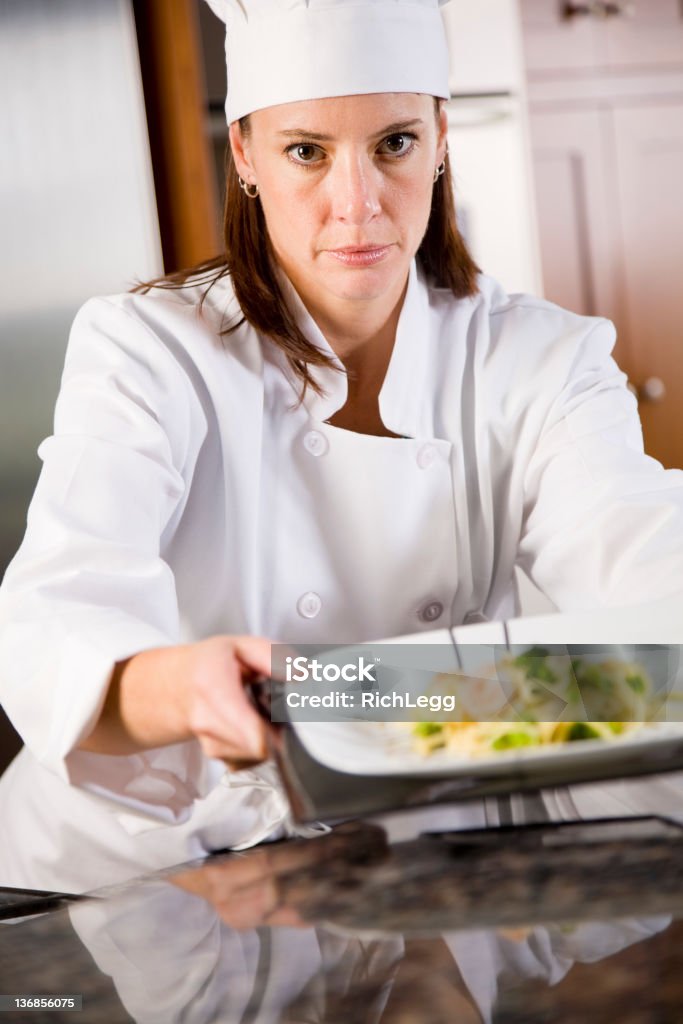 Chef Working in a Kitchen A chef working in a kitchen. Adult Stock Photo