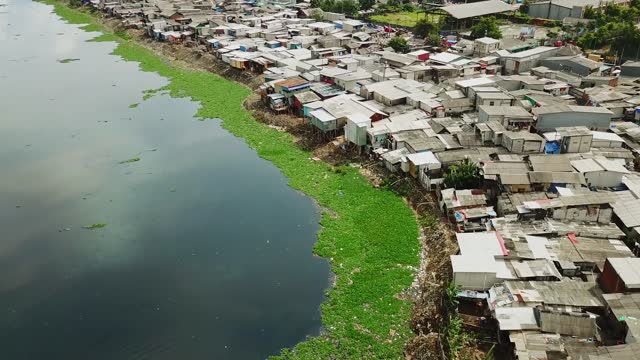 Crowded slum houses on dirty lakeside