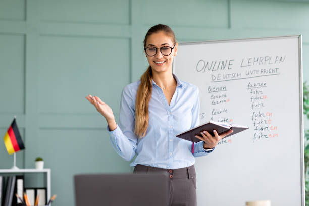 istock Studying German online. Cheerful female teacher giving online foreign language lesson, using laptop 1368561453