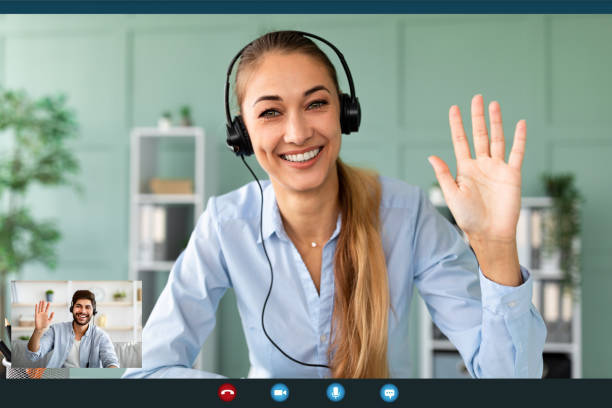 Happy female teacher wearing headphones while having video conference, waving and smiling to webcamera, screenshot Happy female teacher wearing headphones while having video conference, waving and smiling to webcamera, screenshot. Videocall interface, app display, videotelephony and telecommuting video still stock pictures, royalty-free photos & images