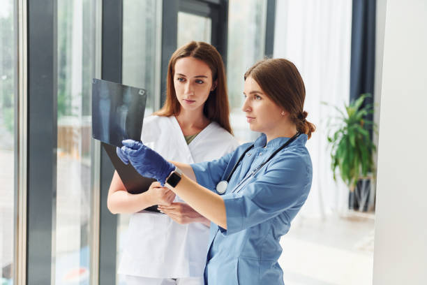 istock With documents. Two doctors in uniform standing indoors and working together 1368562365