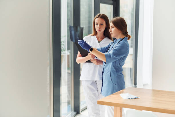 istock With documents. Two doctors in uniform standing indoors and working together 1368562367
