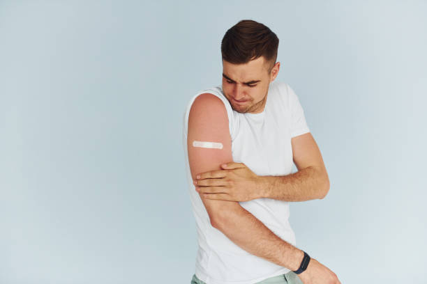 istock Young man in white shirt is indoors against white background 1368562600