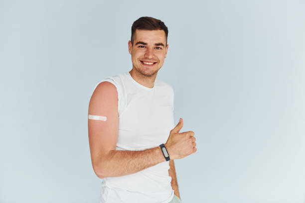 istock Young man in white shirt is indoors against white background 1368562603