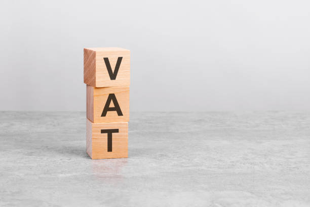 istock wooden cube on a table with text VAT. copy space on right for design, gray background 1368563269
