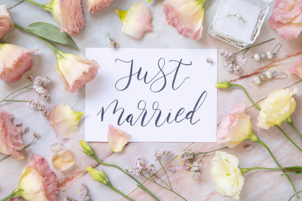 istock Card with the text JUST MARRIED surrounded by pink flowers 1368563782