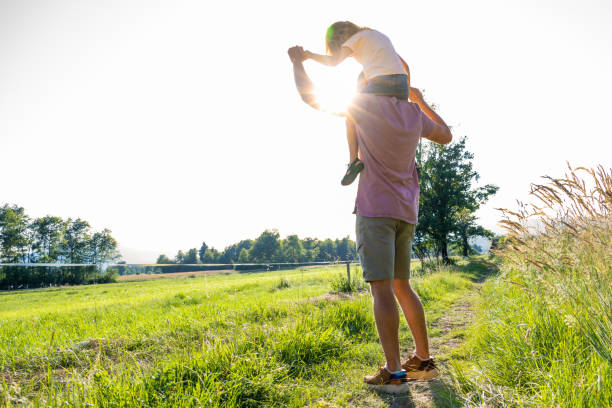 istock Father carrying his daughter on his shoulders 1368565029