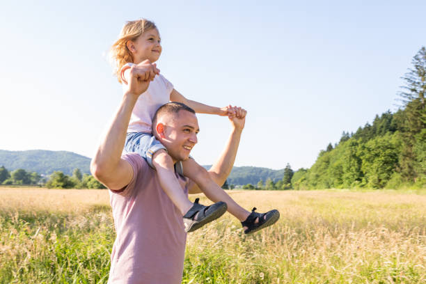 istock Father carrying his daughter on his shoulders 1368565054