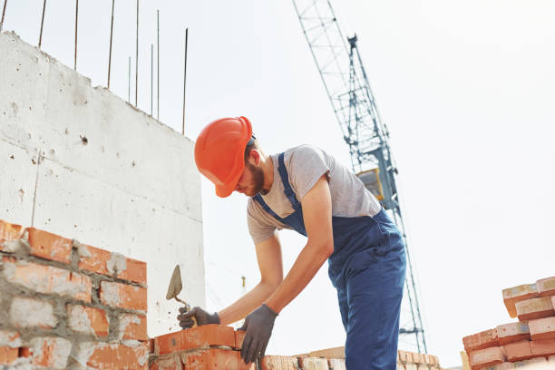 istock Young construction worker in uniform is busy at the unfinished building 1368566967