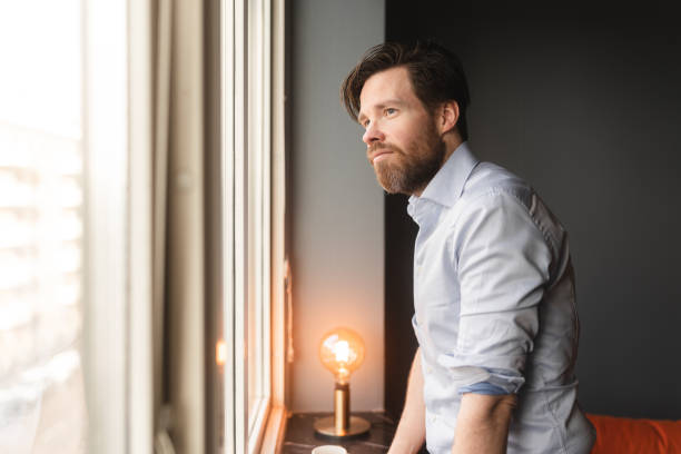istock Man at home waiting by the window 1368569278