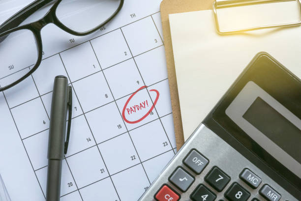 istock Payroll and payday concept with calculator and calendar. 1368570068