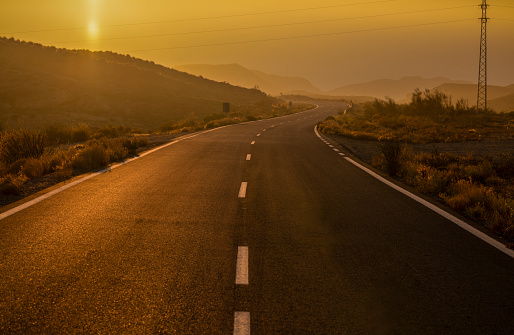 Asphalt road on countryside during sunset. Almeria, Spain
