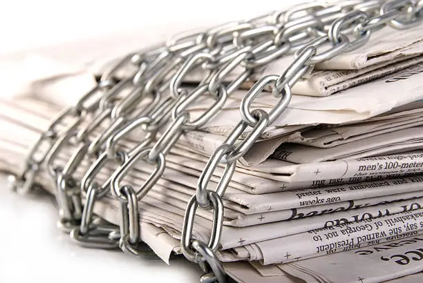 pile of newspapers with metal chain