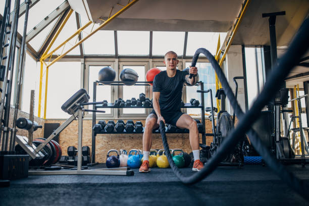istock Young man with battle ropes 1368577955