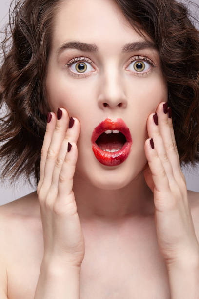 istock Brunette girl with unusual alyapy red female face makeup 1368581012