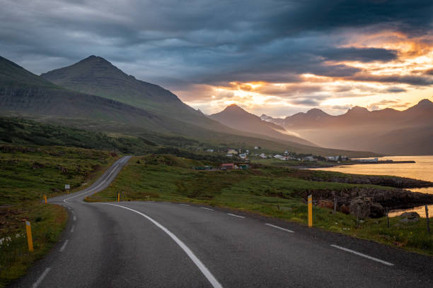 Empty asphalt road and dramatic sunset in southern fjords, Iceland