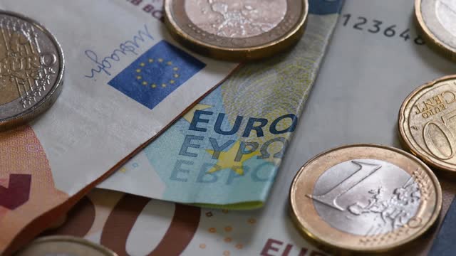 Details of euro cash : banknotes and coins in slow rotation