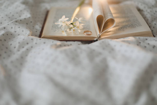 istock Golden ring and open book with folded sheets in heart shape in bed. Wedding concept, Happy Valentine's Day 1368586500