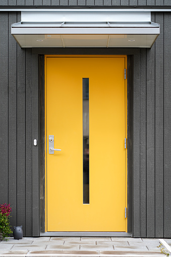 The hand of an old man grasps a handle on a sandblasted glass door