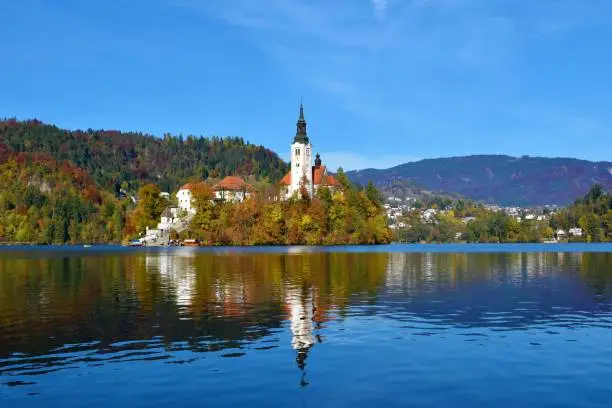 Church of the Assumption of Mary on an island in Bled lake in Gorenjska, Slovenia in autumn and a reflection of thechurch in the water
