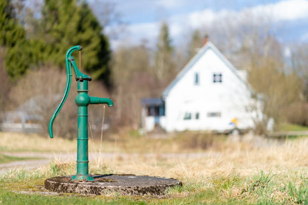 Old manual water pump (Lever pump). Vintage cast iron water pump with handle for pumping.