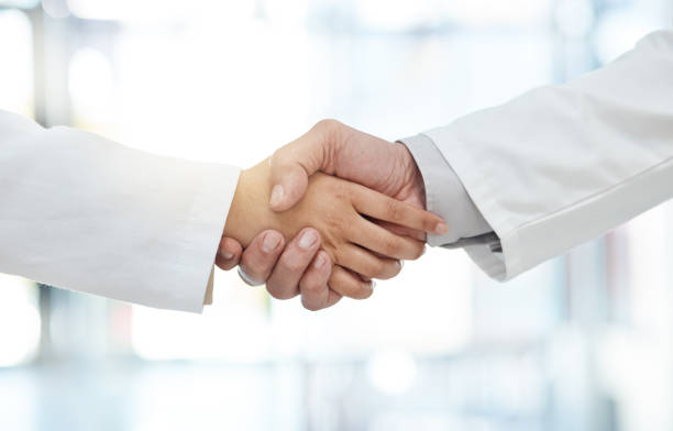 istock Shot of two unrecognizable doctors gesturing a handshake in a hospital 1368589143