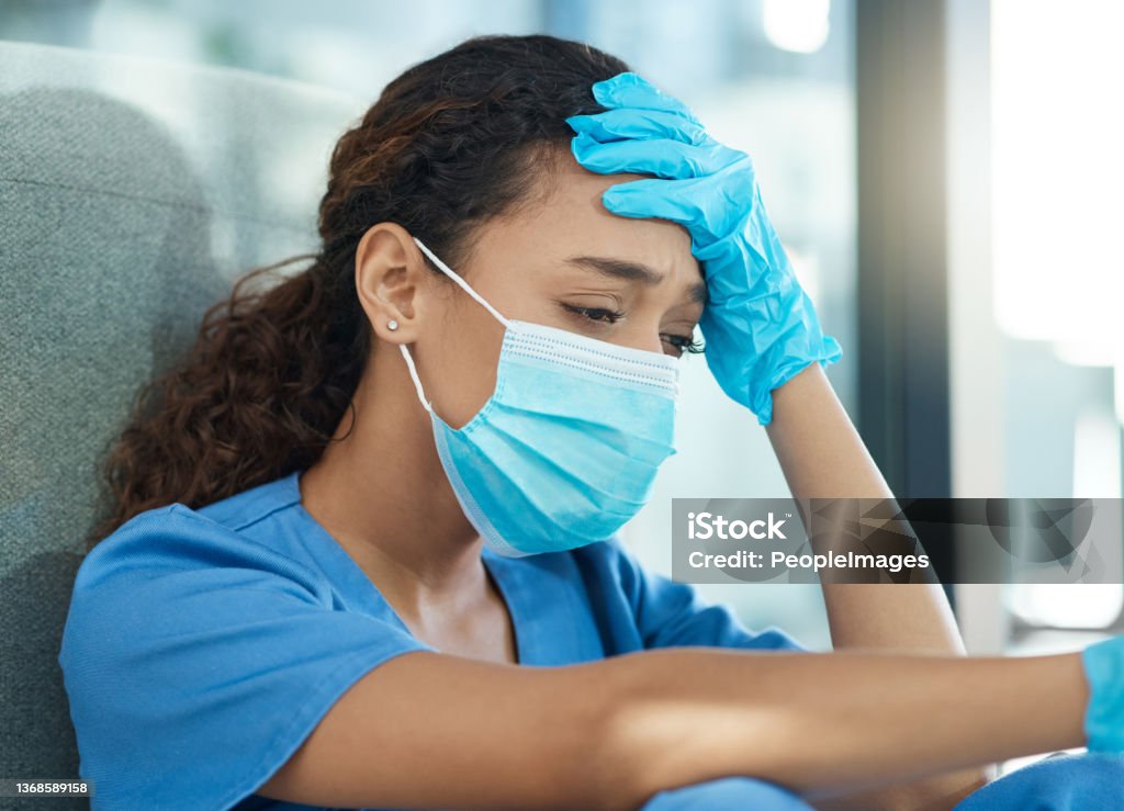 Shot of a female nurse looking stressed while sitting in a hospital Nurses dispense comfort, compassion, and caring Nurse Stock Photo