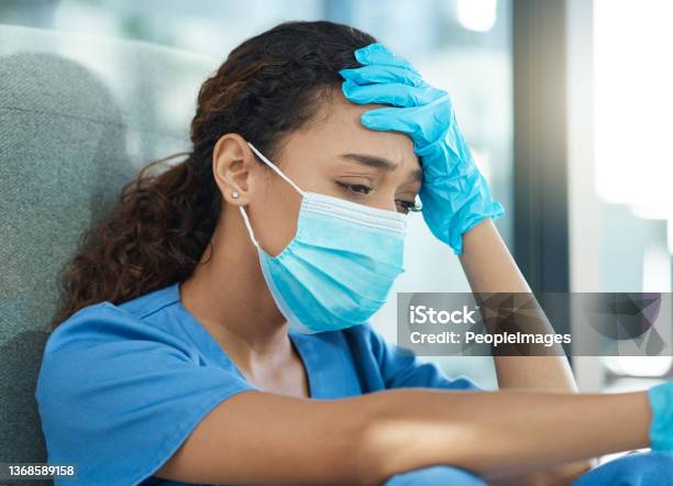 Shot Of A Female Nurse Looking Stressed While Sitting In A Hospital Stock Photo - Download Image Now