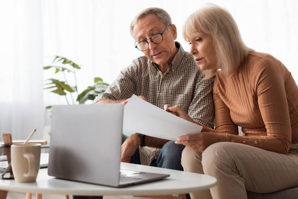 istock Mature Spouses Reading Papers And Documents Holding Letters At Home 1368589555