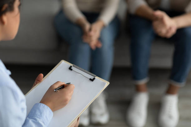 istock Marital counselor taking notes at therapy session with young spouses, holding clipboard and filling information form 1368589690