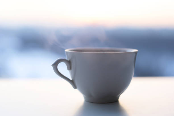 istock Hot coffee cup with smoke on sunrise background 1368597496
