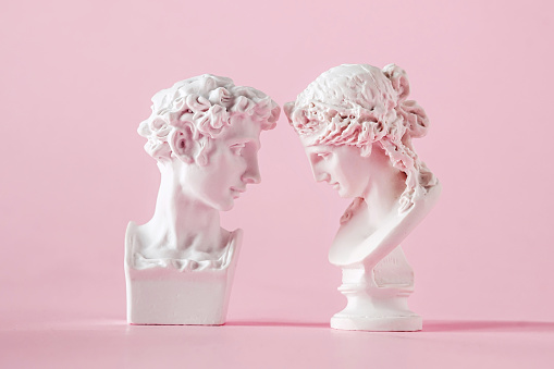 Busto antiguo de yeso de hombre y mujer sobre fondo rosa, concepto de confianza amorosa y san valentín photo