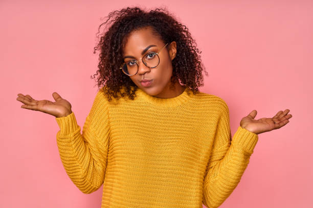 istock Confused beautiful African American woman spreads hands sideways feels doubt while makes choice 1368600296