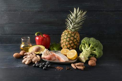 Food for health, vegetables, fish, fruits, nuts and spices for an anti-inflammatory and antioxidant diet, dark rustic wooden background with copy space, selected focus, narrow depth of field