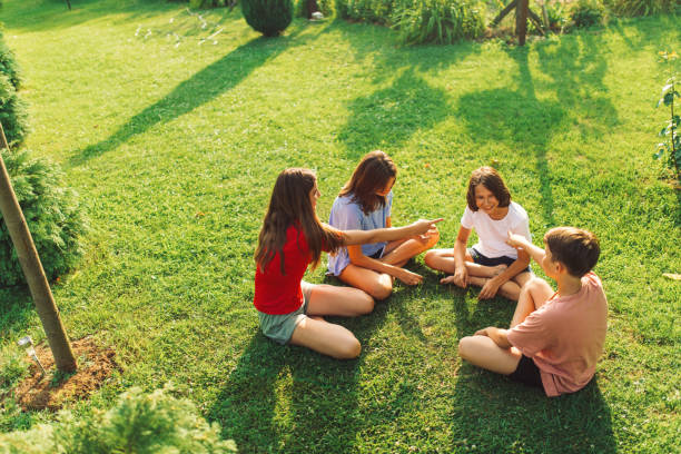 groupe d’enfants jouant à des jeux de main dans la cour arrière - pre teen boy photos et images de collection