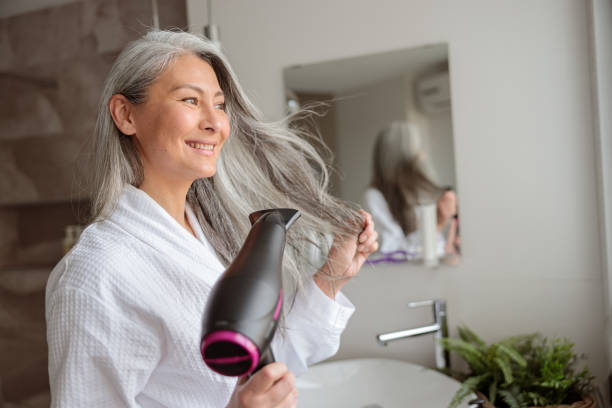istock Asian lady styling hair after taking a bath at home 1368602893