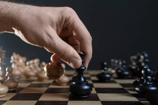 istock Businessman moving chess piece on chess board game. 1368607584