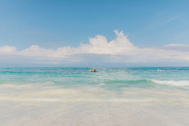 Scenic view of the turquoise colored Indian Ocean, white sand beach and the old fishing boats on Zanzibar island, Tanzania