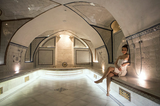 Young woman in a Turkish bath or hammam, lying on the massage table. About 25 years old, Caucasian female.