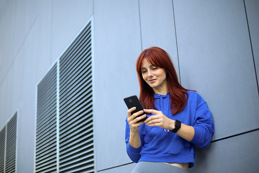 Young woman using a mobile app. About 25 years old, Caucasian redhead.