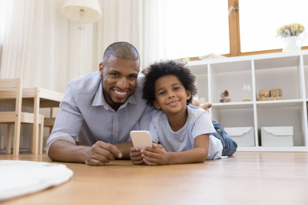 istock Happy African American daddy and son relaxing on heating floor 1368613337