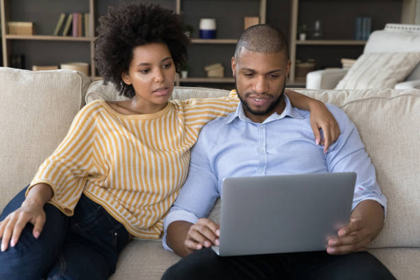 istock Young African American couple using laptop computer at homes 1368613371