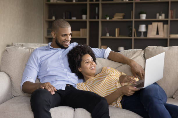 istock Happy relaxed Black married couple resting on sofa 1368613389