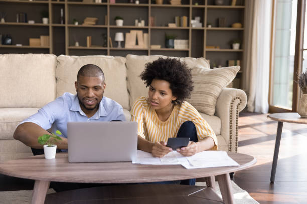 istock Millennial African American couple using laptop computer at home 1368613420