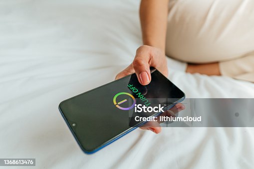 istock Close up of female hand turning off the smartphone 1368613476